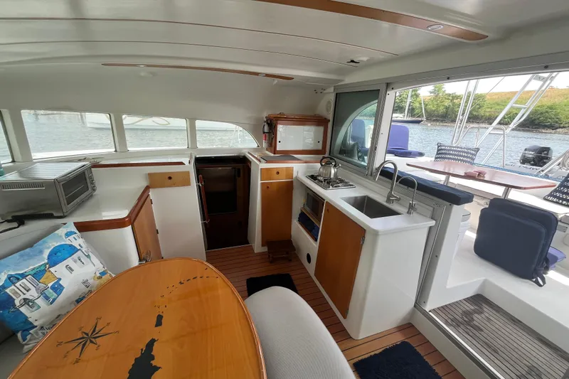 Namaste Yacht Photos Pics Interior of 2004 Lagoon 380 catamaran with kitchen, dining area, and scenic water view.