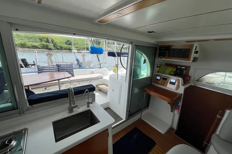 Namaste Yacht Photos Pics Interior view of 2004 Lagoon 380 catamaran, featuring kitchen and cockpit area with scenic water view.