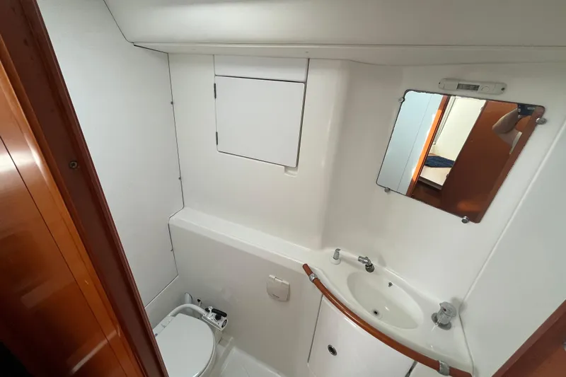 Namaste Yacht Photos Pics Bathroom interior of 2004 Lagoon 380 catamaran with sink, mirror, and toilet.