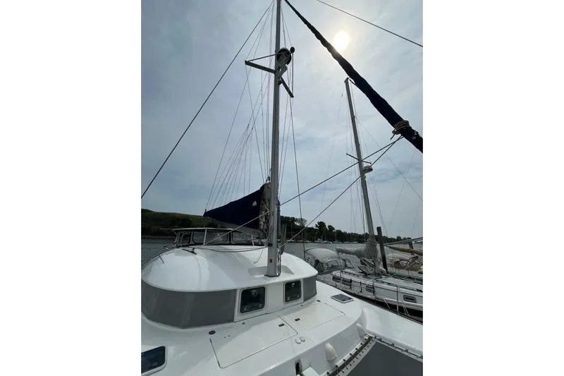 Namaste Yacht Photos Pics 2004 Lagoon 380 catamaran with sails, docked under a cloudy sky.