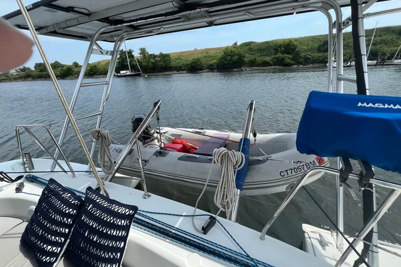 Namaste Yacht Photos Pics Lagoon 380 catamaran with dinghy, docked on a calm river, 2004 model.