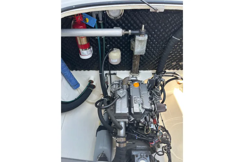 Namaste Yacht Photos Pics Engine compartment of a 2004 Lagoon 380 catamaran, featuring mechanical components and a fire extinguisher.