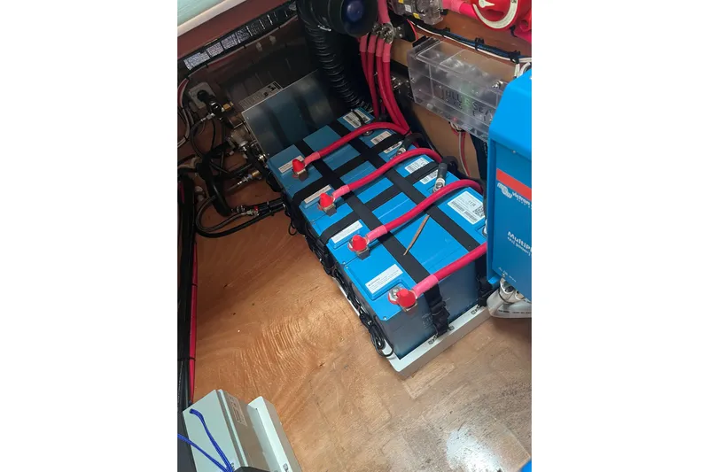 Namaste Yacht Photos Pics Battery setup in a 2004 Lagoon 380 catamaran, featuring blue batteries and red wiring.