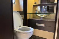 Luxury bathroom in 2006 Azimut 86S yacht with modern fixtures and glass sink.