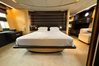 Luxurious bedroom interior of a 2006 Azimut 86S yacht with modern furnishings.
