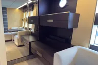 Luxurious interior of 2006 Azimut 86S yacht with modern furnishings and porthole window.