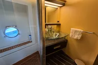 Luxurious bathroom in 2006 Azimut 86S yacht with glass sink and porthole window.