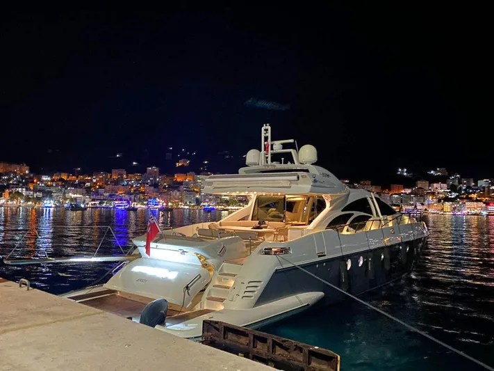  Yacht Photos Pics Luxury Azimut 86S yacht docked at night, city lights reflecting on water.