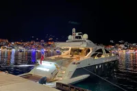 Luxury Azimut 86S yacht docked at night, city lights reflecting on water.