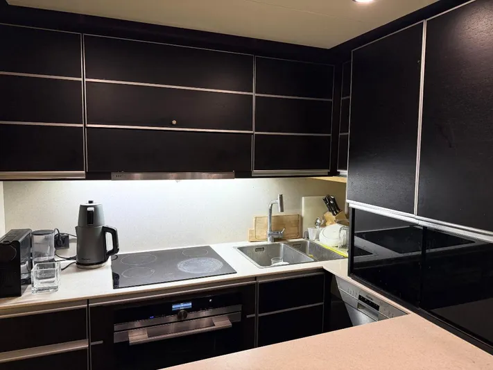  Yacht Photos Pics Modern kitchen interior on a 2006 Azimut 86S yacht, featuring sleek black cabinetry.