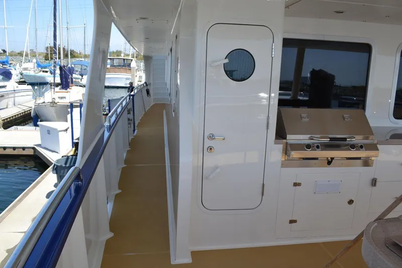 Allseas Yacht Photos Pics Side deck of 2016 Allseas Expedition 92 yacht with outdoor grill and marina view.