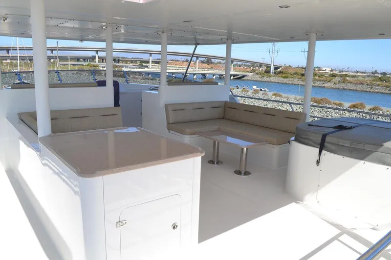 Allseas Yacht Photos Pics Allseas Expedition 92 (2016) yacht deck with seating area and table, docked by the water.