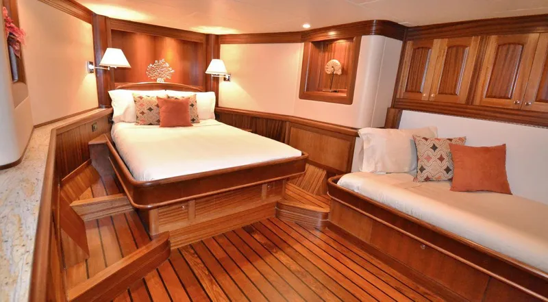 Allseas Yacht Photos Pics Luxurious wooden cabin interior of 2016 Allseas Expedition 92 yacht with bed and sofa.