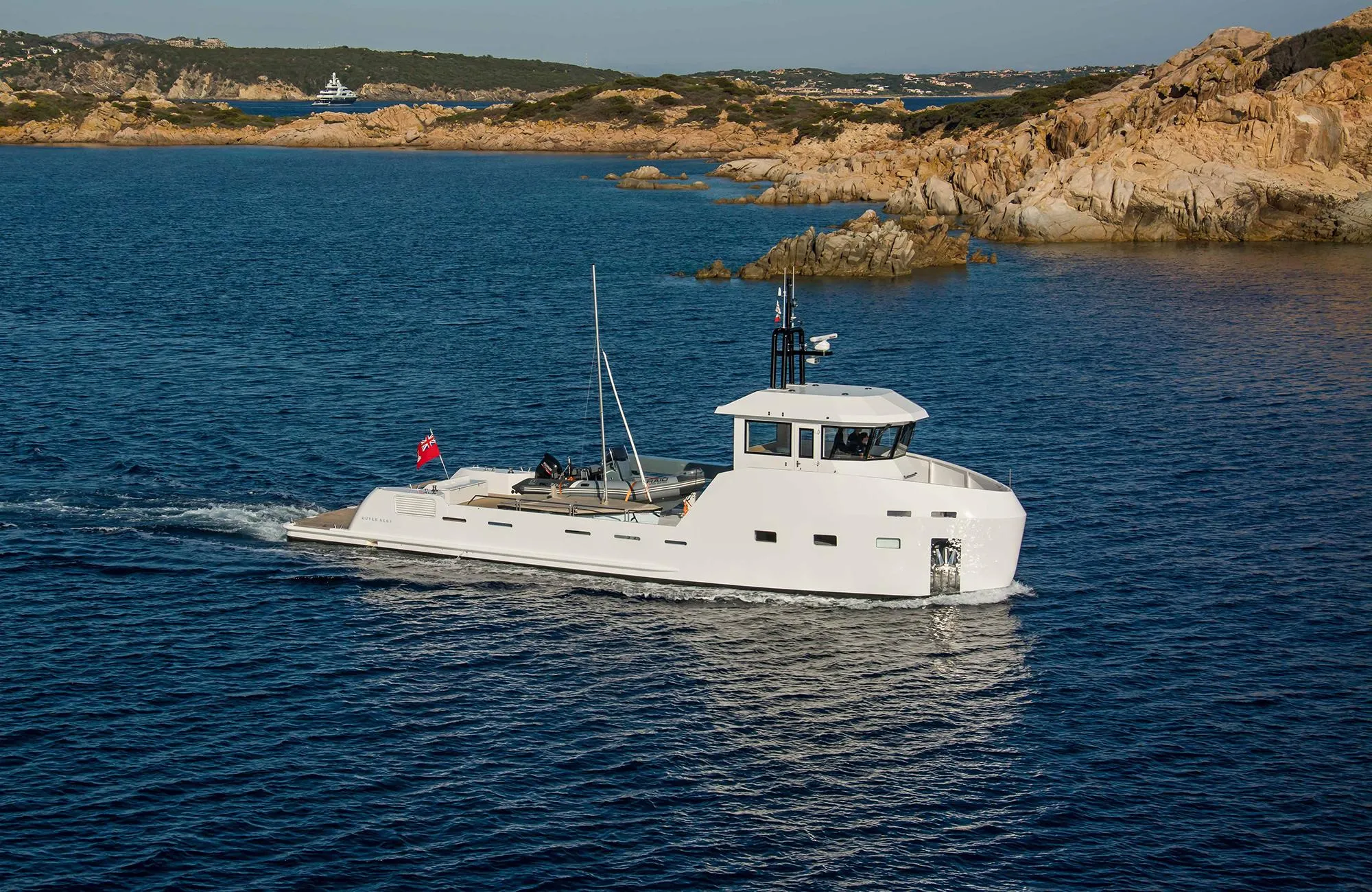 Outer Reef Yachts 20 YXT 2027 cruising near rocky coastline.