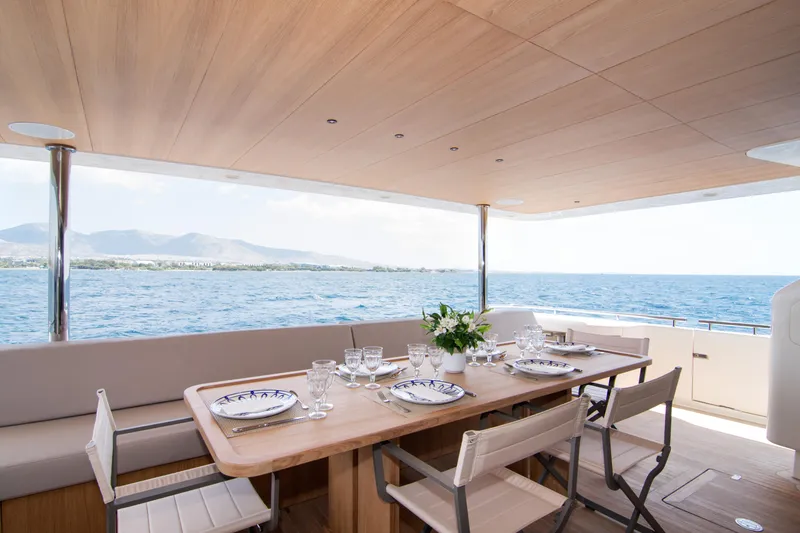 Whisper V Yacht Photos Pics Outdoor dining area on 2002 Ferretti Yachts 112 Custom Line, overlooking the sea.