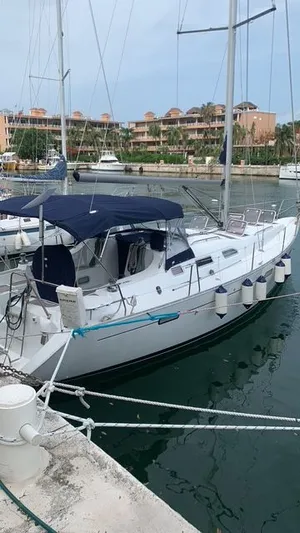 "chula" Yacht Photos Pics 2006 Beneteau Oceanis 393 sailboat docked in a marina, featuring a blue canopy.