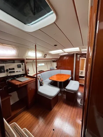 "chula" Yacht Photos Pics Interior of 2006 Beneteau Oceanis 393 sailboat with cozy seating and wooden finishes.