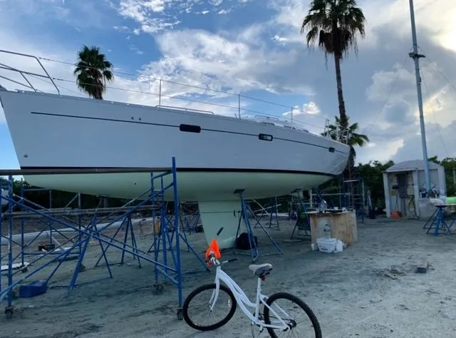 "chula" Yacht Photos Pics Sailboat Beneteau Oceanis 393 (2006) on stands, with a bicycle nearby, under a cloudy sky.