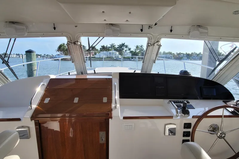 Future 7 Yacht Photos Pics 2018 MJM 50z yacht helm with wooden accents, overlooking serene waterfront homes.