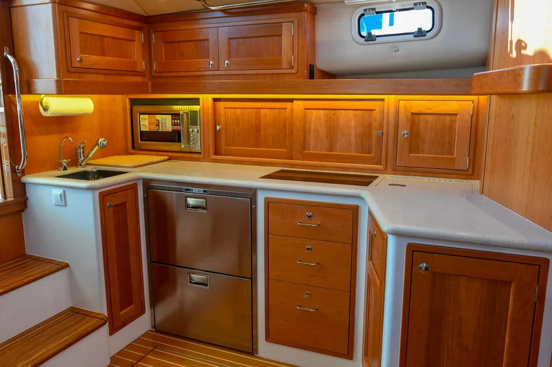 Future 7 Yacht Photos Pics Luxurious 2018 MJM 50z yacht kitchen with wooden cabinetry and modern appliances.