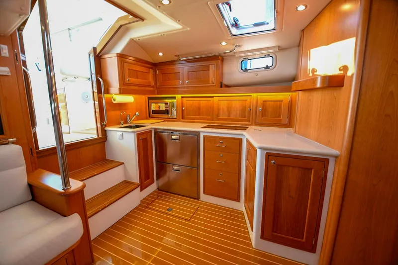 Future 7 Yacht Photos Pics Luxurious 2018 MJM 50z yacht interior with wooden cabinetry and modern kitchen amenities.