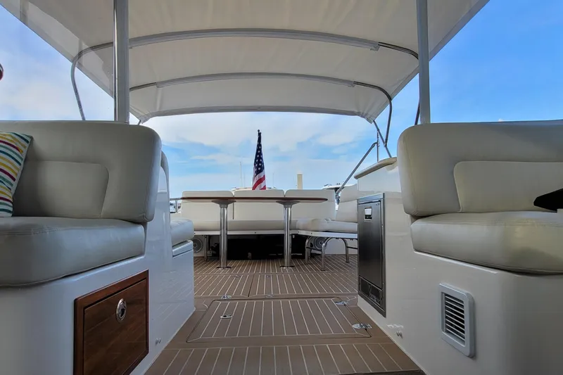 Future 7 Yacht Photos Pics 2018 MJM 50z yacht interior with seating, table, and American flag in the background.