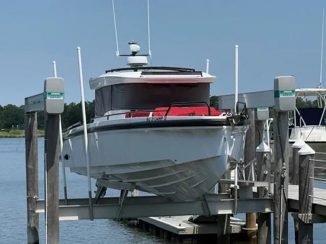 Yacht Photos Pics 2021 Axopar 37 XC CROSS CABIN boat docked on a lift by the water.