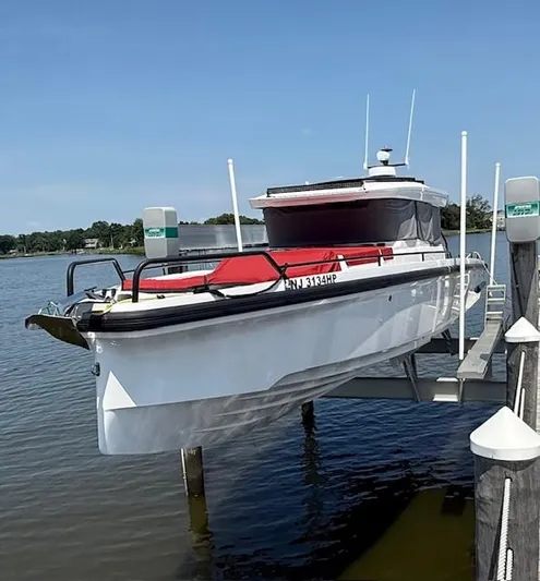  Yacht Photos Pics 2021 Axopar 37 XC CROSS CABIN boat docked on a lift by the water.