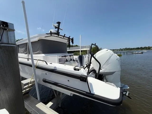  Yacht Photos Pics 2021 Axopar 37 XC CROSS CABIN boat docked by a serene riverside.