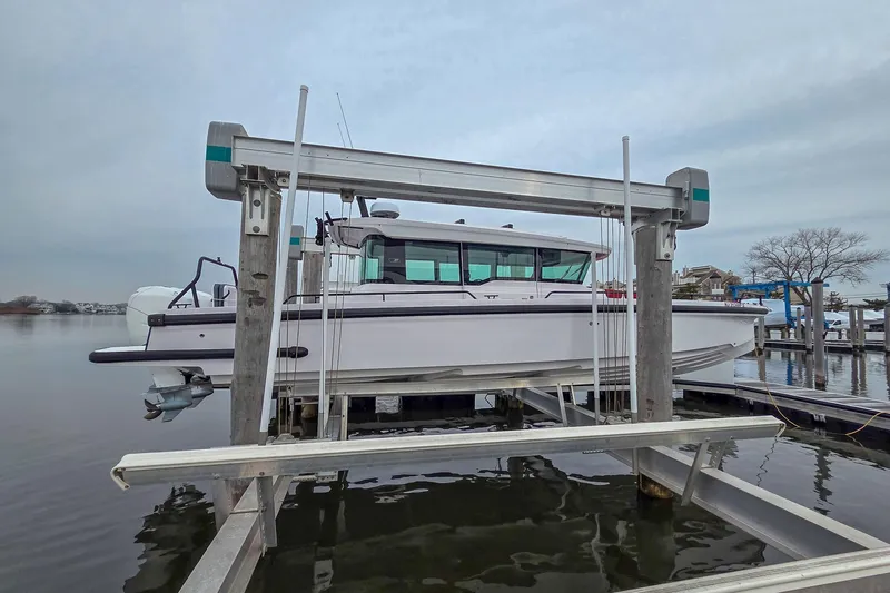  Yacht Photos Pics 2021 Axopar 37 XC Cross Cabin boat on a lift at a marina.