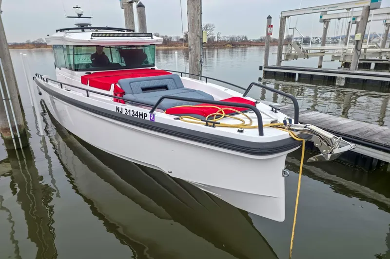  Yacht Photos Pics 2021 Axopar 37 XC Cross Cabin boat docked, featuring sleek design and vibrant seating.