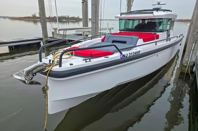  Yacht Photos Pics 2021 Axopar 37 XC Cross Cabin boat docked, featuring red and gray seating.