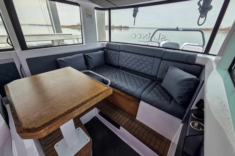  Yacht Photos Pics Luxurious interior of 2021 Axopar 37 XC Cross Cabin with plush seating and wooden table.