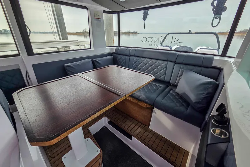  Yacht Photos Pics Interior of 2021 Axopar 37 XC Cross Cabin with elegant seating and wooden table.