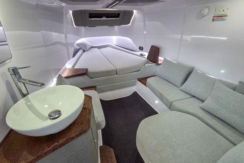  Yacht Photos Pics 2021 Axopar 37 XC Cross Cabin interior with modern bed, sofa, and sink.