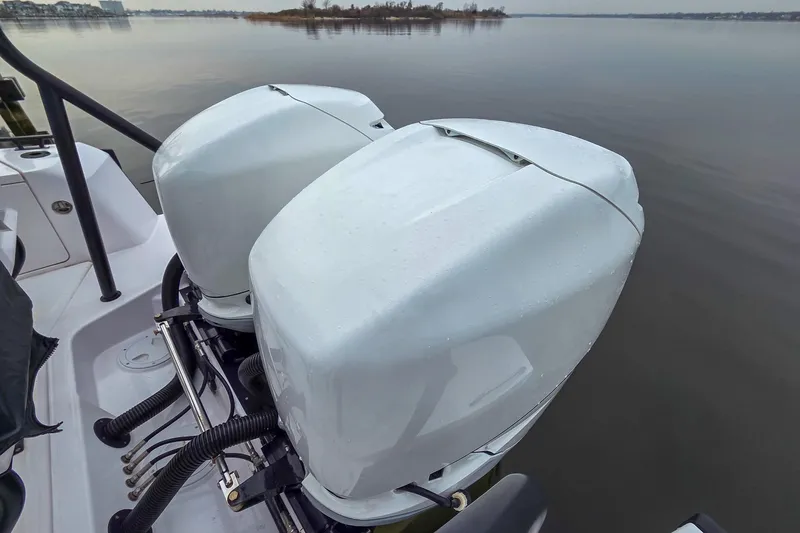  Yacht Photos Pics Twin outboard engines on a 2021 Axopar 37 XC Cross Cabin boat, docked on calm water.