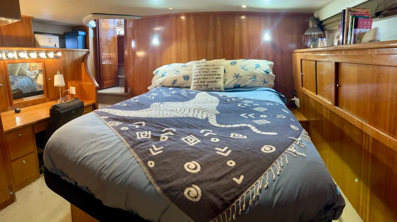 Knot 2 Late Yacht Photos Pics Luxurious bedroom interior of 2003 Navigator 57 Rival yacht with cozy bed and wooden decor.