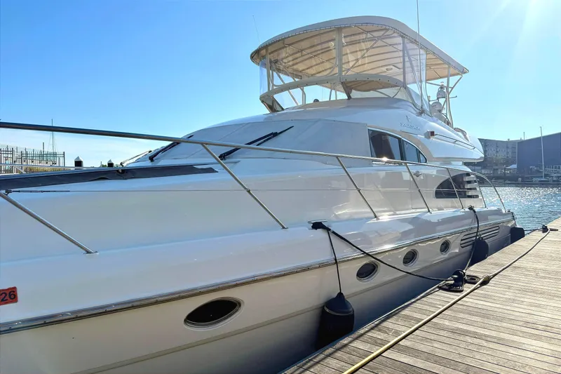  Yacht Photos Pics Luxury Fairline Squadron 56 yacht docked, 2000 model, gleaming under clear blue sky.