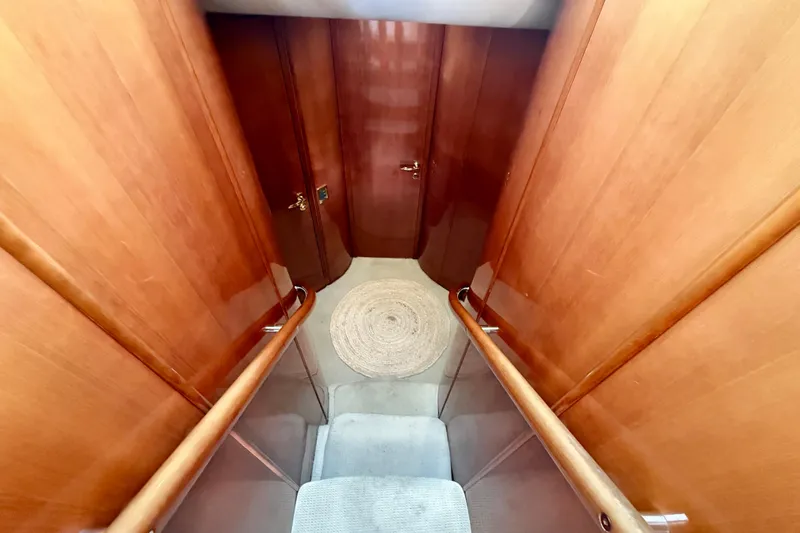  Yacht Photos Pics Interior view of 2000 Fairline Squadron 56 yacht with wooden walls and carpeted stairs.