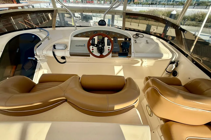  Yacht Photos Pics Luxurious helm of 2000 Fairline Squadron 56 yacht with tan leather seats and Garmin navigation.