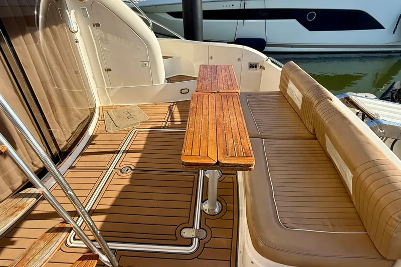  Yacht Photos Pics Luxurious 2000 Fairline Squadron 56 yacht deck with wooden table and cushioned seating.