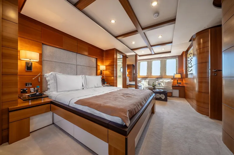 Arion Yacht Photos Pics Luxurious bedroom interior on 2011 Guy Couach 121' yacht, featuring elegant wood paneling and modern design.