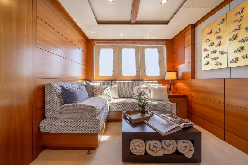 Arion Yacht Photos Pics Luxurious interior of 2011 Guy Couach 121' yacht with elegant wood paneling and cozy seating area.
