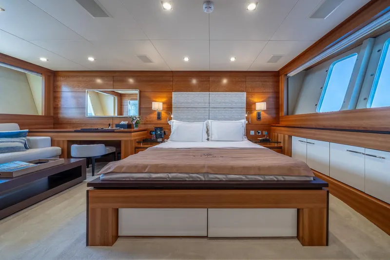 Arion Yacht Photos Pics Luxurious bedroom interior on 2011 Guy Couach 121' yacht, featuring elegant wood finishes.