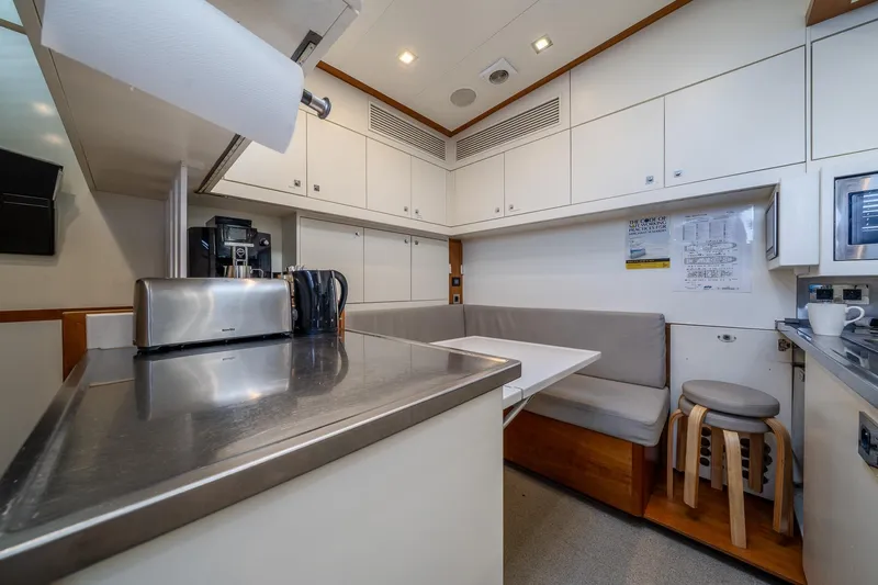 Arion Yacht Photos Pics Modern kitchen area on a 2011 Guy Couach 121' yacht, featuring sleek cabinetry and seating.