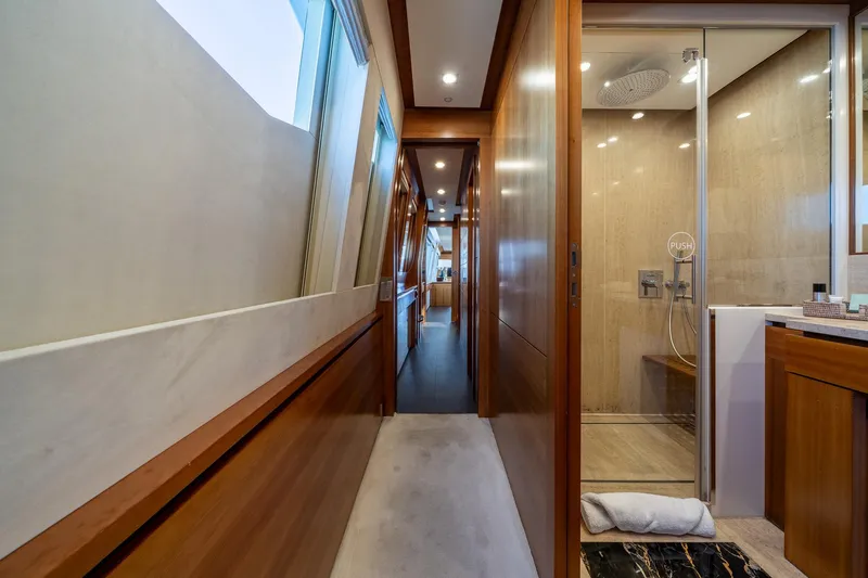 Arion Yacht Photos Pics Luxurious interior hallway and bathroom of 2011 Guy Couach 121' yacht, featuring elegant wood finishes.