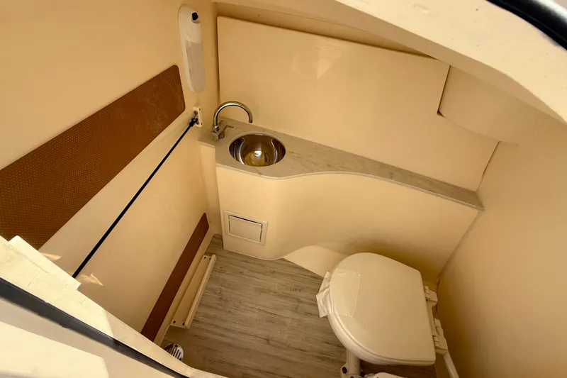  Yacht Photos Pics 2024 Scout 240 Dorado boat interior with compact bathroom, sink, and toilet.