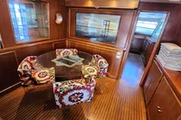 Luxurious 1984 De Groot yacht interior with floral chairs and glass table.