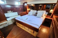 Luxurious 1984 De Groot yacht cabin with elegant wood finish and cozy bedding.