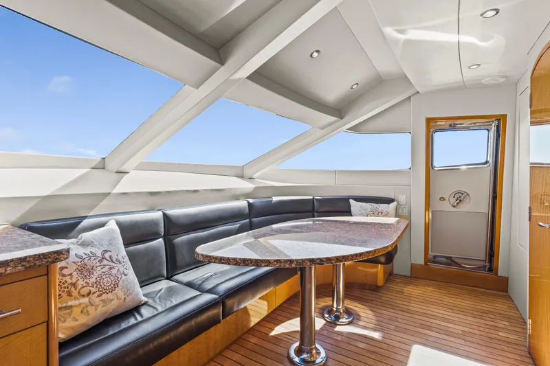 Time-2 Fly Yacht Photos Pics Luxurious interior of 2006 Hatteras 80 Motor Yacht Sky Lounge with elegant seating and table.